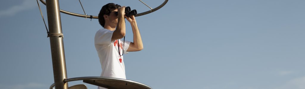 full-shot-lifeguard-with-binoculars-seaside